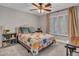 Cozy bedroom with natural light, a ceiling fan, a star-themed quilt and a plush upholstered headboard at 8654 W Melinda Ln, Peoria, AZ 85382