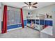 Bright bedroom featuring a bunk bed, ceiling fan, and natural light from the window with shutters and red drapes at 8654 W Melinda Ln, Peoria, AZ 85382