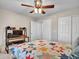 Comfortable bedroom with a desk, ceiling fan, and patterned quilt, and includes sliding closet doors at 8654 W Melinda Ln, Peoria, AZ 85382