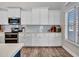 Updated kitchen features white cabinetry, subway tile backsplash, and stainless steel appliances at 8654 W Melinda Ln, Peoria, AZ 85382