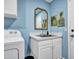 Laundry area with sink, cabinets, framed art, and modern fixtures at 8654 W Melinda Ln, Peoria, AZ 85382