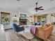 Bright living room featuring a fireplace, ceiling fan, and access to the backyard at 8654 W Melinda Ln, Peoria, AZ 85382