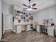 Bright office space with a ceiling fan, built-in cabinets and a desk at 8654 W Melinda Ln, Peoria, AZ 85382