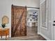 Rustic barn door leading to an office with built-in shelving and desk at 8654 W Melinda Ln, Peoria, AZ 85382