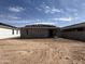 New construction backyard features dirt lot and exterior of home with tile roofing and stucco awaiting final landscaping at 9540 W Parkway Dr, Tolleson, AZ 85353