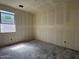 Unfinished bedroom with bare walls, a gray concrete floor and a window with construction documents taped to the inside glass at 9540 W Parkway Dr, Tolleson, AZ 85353