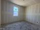 A room with bare concrete floors and primer on the walls and ceiling with a window that has construction paper on it at 9540 W Parkway Dr, Tolleson, AZ 85353
