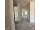 Unfinished hallway with primer walls and concrete flooring with an entrance to an unfinished room with a view of a window at 9540 W Parkway Dr, Tolleson, AZ 85353