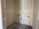 Small laundry room that has been primed with concrete flooring and studs exposed at the entry way at 9540 W Parkway Dr, Tolleson, AZ 85353
