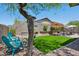 Charming backyard with artificial turf, patio seating and turquoise chairs for relaxing at 12062 W Duane Ln, Peoria, AZ 85383
