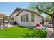 Private backyard with synthetic grass, mature landscaping, and covered patio at 12062 W Duane Ln, Peoria, AZ 85383