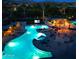 Nighttime view of the community pool featuring ample seating, lights, and recreational space for outdoor enjoyment at 12062 W Duane Ln, Peoria, AZ 85383