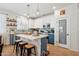 Beautiful kitchen featuring a center island, bar stool seating, modern pendant lights, and two-tone cabinetry at 12062 W Duane Ln, Peoria, AZ 85383