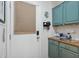 Bright laundry room with teal cabinets and modern door hardware at 12062 W Duane Ln, Peoria, AZ 85383