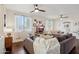 Spacious living room with hardwood floors, large windows, comfortable seating, and modern ceiling fans at 12062 W Duane Ln, Peoria, AZ 85383