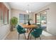 Dining room with lots of sunlight, modern chandelier, wood table and six stylish teal chairs at 19351 E Apricot Ln, Queen Creek, AZ 85142