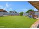 Backyard featuring a wooden play structure, lush grass, and a privacy fence at 2035 E Escuda Rd, Phoenix, AZ 85024