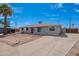 Charming single-story home featuring a gray exterior, palm tree, and expansive front yard at 3212 N 49Th Ln, Phoenix, AZ 85031