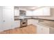 Modern kitchen boasts white cabinets, stainless steel appliances, and ample countertop space at 3212 N 49Th Ln, Phoenix, AZ 85031