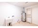 Utility room featuring a sink, water heater, and built-in shelving for storage at 3212 N 49Th Ln, Phoenix, AZ 85031