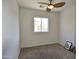 A bright bedroom featuring neutral carpeting, a ceiling fan, and a window with views of the outside at 34940 N 30Th Ave, Phoenix, AZ 85086