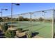 Tennis court with green surface and fencing, surrounded by desert landscaping at 34940 N 30Th Ave, Phoenix, AZ 85086