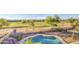 A view of the pool and backyard, with golf course in the distance. Nice landscaping at 43324 W Desert Fairways Dr, Maricopa, AZ 85138