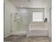 Bathroom showcasing a glass enclosed shower and separate soaking tub at 43324 W Desert Fairways Dr, Maricopa, AZ 85138