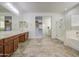Bright bathroom with double vanity, walk-in shower and tub, and walk-in closet at 43324 W Desert Fairways Dr, Maricopa, AZ 85138