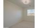 Bedroom with neutral carpet and a view of the neighborhood through a large window at 43324 W Desert Fairways Dr, Maricopa, AZ 85138
