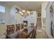 Bright dining room with wood table, chairs, and modern chandelier at 43324 W Desert Fairways Dr, Maricopa, AZ 85138