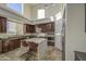 Bright kitchen features dark wood cabinets, a center island with seating, and stainless steel appliances at 43324 W Desert Fairways Dr, Maricopa, AZ 85138