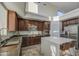 Bright kitchen features dark wood cabinets, stainless steel appliances, and a center island with seating at 43324 W Desert Fairways Dr, Maricopa, AZ 85138