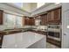 Bright kitchen features dark wood cabinets, stainless steel appliances, and a center island at 43324 W Desert Fairways Dr, Maricopa, AZ 85138
