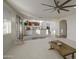 Open-concept living room with access to the dining room, kitchen, and outdoor patio at 43324 W Desert Fairways Dr, Maricopa, AZ 85138