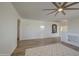 Spacious living room with wood floors, neutral walls, and ceiling fan provides a welcoming atmosphere at 43324 W Desert Fairways Dr, Maricopa, AZ 85138