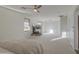 Spacious main bedroom featuring a fireplace, ceiling fan, and natural light at 43324 W Desert Fairways Dr, Maricopa, AZ 85138