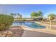 Relaxing backyard pool area featuring a desert landscaped, complete with a pebble tec pool at 43324 W Desert Fairways Dr, Maricopa, AZ 85138