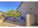 A view of the home's side yard featuring an orange tree and AC units at 43324 W Desert Fairways Dr, Maricopa, AZ 85138