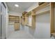 Bright walk-in closet with natural light, built-in shelves and drawers for organized storage at 43324 W Desert Fairways Dr, Maricopa, AZ 85138