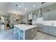 Open kitchen with gray cabinets, quartz countertops, stainless steel appliances, and a large island and view to dining area at 4489 E Skousen St, Gilbert, AZ 85295