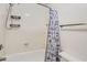 Bright bathroom showcases a shower and tub combo with modern fixtures and a blue patterned curtain at 514 E Vaughn Ave, Gilbert, AZ 85234