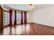 Primary bedroom with wood floors and large windows with red curtains at 514 E Vaughn Ave, Gilbert, AZ 85234
