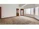 Spacious bedroom features light walls, neutral carpet, large windows, and a private access door to a balcony at 514 E Vaughn Ave, Gilbert, AZ 85234