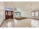Bright open living room with tile flooring, large windows and statement chandelier at 514 E Vaughn Ave, Gilbert, AZ 85234