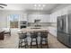 Bright kitchen features white cabinetry, stainless steel appliances, and a center island with bar stool seating at 7145 E Cuernavaco Way, Gold Canyon, AZ 85118