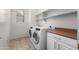 The laundry room boasts a side-by-side washer and dryer, cabinets and shelving, and a window for natural light at 7145 E Cuernavaco Way, Gold Canyon, AZ 85118