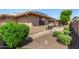 Charming backyard featuring a stone patio area with outdoor seating and lush landscaping at 10903 E Ocaso Ave, Mesa, AZ 85212