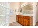 Bathroom showcasing a vanity with wood cabinetry, a large mirror, and a glass block window at 10903 E Ocaso Ave, Mesa, AZ 85212