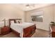 Cozy bedroom featuring a ceiling fan, a plush bed, and a window with serene outdoor views at 10903 E Ocaso Ave, Mesa, AZ 85212